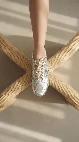 Zapatilla de cuero con diseño minimalista, cordones al tono y detalles de costuras laterales. Cuenta con suela plana y estructura ligera.