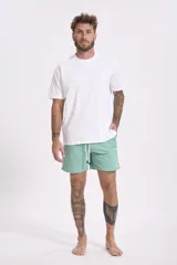 Short de baño verde menta con cordón ajustable blanco y etiqueta lateral.