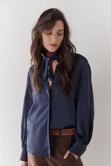 Camisa azul marino de satén con cuello clásico, cierre frontal con botones y mangas largas con puños abotonados.