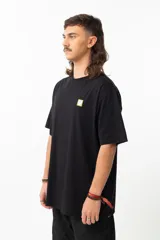 Remera negra de algodón con estampa en la espalda de una ilustración de Adrian Willard que representa una mujer con una rosa en el pelo y un cráneo fumando, sobre un fondo con damero y texto en japonés.