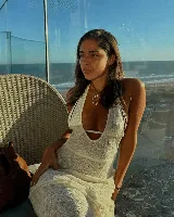 Vestido largo de tejido de punto calado color crema, con escote halter y espalda descubierta.