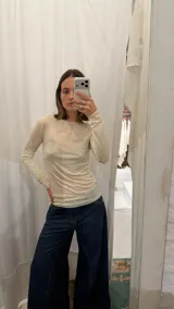 Remera de manga larga con cuello redondo, confeccionada en tejido de punto suave y elástico, con un ajuste al cuerpo.