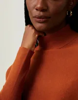 Sweater de punto color naranja, con cuello alto y mangas dolman.