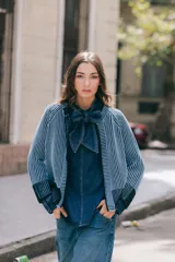 Saco reversible de tejido vanizado con cuello a la base y manga larga. Presenta un diseño bicolor que crea un efecto visual desgastado y cuenta con cierre frontal de botones negros.