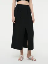 Falda negra de corte midi, con pinzas en la cintura, pretina con elástico en la parte trasera y tajo frontal.