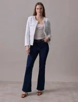 Chaqueta Nanette de tejido tweed color blanco, con escote mao, abertura central y bolsillos delanteros. Presenta apliques de botones perlados en los puños y terminación desflecada.