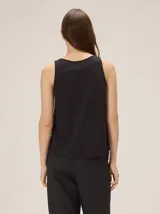 Musculosa de algodón color azul marino, con escote en V y un bordado artesanal de flor en el frente con contorno naranja y relleno dorado.