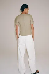 Camiseta de manga corta confeccionada en hilatura con mezcla de algodón, con diseño de tejido en rib y corte slim fit. Presenta cuello redondo y costuras verticales decorativas en el frente.