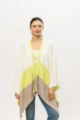 Ruana tejida de punto en algodón, con diseño color block en blanco, verde lima y beige. Tiene bolsillos laterales.