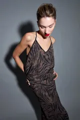 Top sin mangas de tirantes finos con estampado animal print, escote en V y ribetes negros.