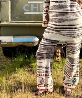 Vestido midi de lana merino tejido a mano, de color blanco con líneas horizontales marrones, mangas oxford y detalles bordados a mano en los puños.