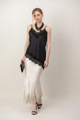 Musculosa de satén color beige con aplicación de encaje negro en el escote y breteles finos ajustables.