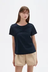 Blusa de viscosa color natural, con cuello a la base, manga corta y detalle de plisado cruzado en el frente. Presenta un corte holgado.