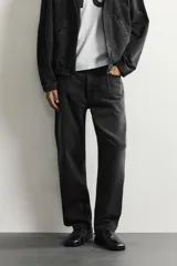 Pantalón de jean corte slim fit con efecto lavado, tiro medio, cinco bolsillos y cierre frontal con cremallera y botón.