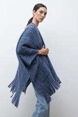 Ruana de punto color azul con estampado de espiga en dos tonos de azul, diseño holgado, con bolsillos y flecos en el borde inferior.