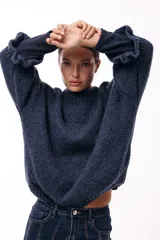 Sweater de tejido de punto con silueta relajada, cuello redondo y mangas tres cuartos con volumen abuchado.