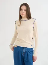 Polera de cuello alto confeccionada en tela rib color blanco, con mangas largas y hombreras. Presenta pespuntes en contraste en las terminaciones del cuello, hombros y puños.