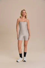 Jumpsuit corto de ajuste ceñido con escote recto y breteles finos. Confeccionado en tejido con acabado satinado y textura acanalada, ofrece compresión media y gran elasticidad.