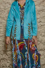 Blazer celeste de terciopelo con corte al cuerpo y detalles de cuero marrón en la parte delantera y en los puños.