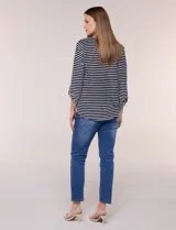 Remera de calce relajado y silueta fluida, con escote en V y mangas tres cuartos con presilla y botón. Diseño de rayas dispuestas en ángulo tipo espiga en el delantero y ruedo redondeado.