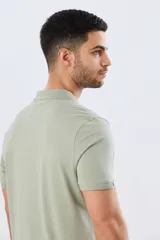 Remera polo de manga corta en color azul melange, con cuello camisero, cierre frontal de dos botones y pequeño bordado en el pecho.