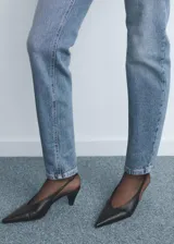 Jeans tipo mom-fit de tiro alto con diseño de cinco bolsillos, trabillas y cierre frontal con cremallera y botón.