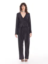 Pantalón negro plisado de corte amplio con elástico en la cintura y bolsillos laterales.