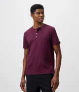 Remera de algodón texturizado color bordó, de corte regular con mangas cortas, cuello redondo y abertura frontal estilo Henley con botones.