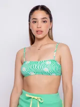 Top de bikini recto con estampado de flores y ondas en tonos verde y blanco. Tiene breteles finos regulables, se ata en la espalda y cuenta con forro y copas desmontables.