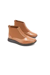 Botín tipo Chelsea de caña baja color caramelo, confeccionado en cuero vacuno liso con detalles texturizados efecto escama en el talón y la puntera. Cuenta con inserciones elásticas laterales para un calce fácil y una plataforma ligera de color oscuro.
