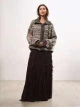 Saco tejido de lana con diseño de rayas horizontales en tonos tierra, cuello solapa, cierre frontal con botones y mangas largas holgadas.