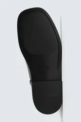 Bota de piel negra con diseño minimalista, cierre de cremallera lateral, horma cuadrada y suela a tono con ligero tacón.