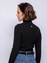 Polera negra de cuello alto y manga larga, de tejido elastizado.