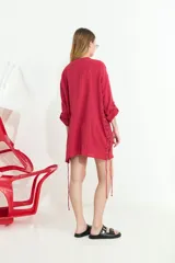 Camisa de algodón blanca, de manga larga y corte oversize, con diseño abierto en los laterales ajustable mediante cordón y ojalillos.
