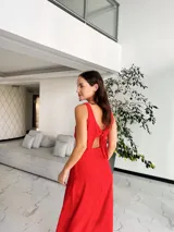 Vestido largo de crepé con acabado metalizado, escote en V profundo con detalle de aro central, aberturas laterales en la cintura y falda con tajo frontal.