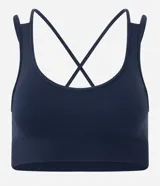 Top deportivo Get Over confeccionado en poliamida seamless, con escote redondo, breteles cruzados en la espalda y diseño sin costuras para mayor comodidad.