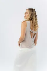 Top sin mangas de lino metalizado con acabado brillante, escote cerrado y espalda abierta con lazo ajustable.