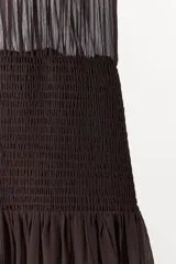 Vestido largo de tirantes finos con escote en pico, cuerpo con frunces elásticos y detalle de encaje a tono en la parte superior. Cuenta con forro interior y falda fluida.