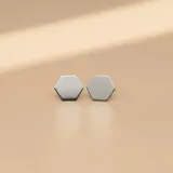 Par de aros tipo stud con diseño geométrico hexagonal, confeccionados en plata 925 con acabado pulido.