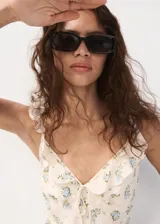 Vestido midi de viscosa color beige con estampado de flores azules, escote en V con volantes y tirantes finos ajustables.