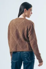 Cardigan de punto color marrón con diseño de rombos bordados en hilo claro. Presenta cuello redondo, cierre frontal con botones y mangas largas con detalle de letras bordadas.