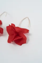 Aros colgantes con diseño de flor en color negro, con gancho metálico dorado.