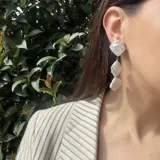 Aros colgantes con tres perlas barrocas blancas.