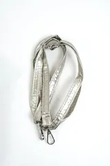 Cartera acolchada negra de material sintético con efecto brillante y costuras en rombos. Cuenta con solapa frontal y una correa corta de cadena gruesa de eslabones plásticos negros.