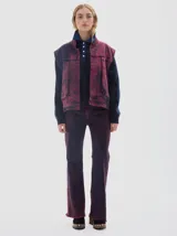 Chaleco utility de denim oversized con bolsillos cargo y lavado washed en tonos bordó y azul.