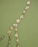 Collar artesanal compuesto por piezas irregulares de alpaca unidas por eslabones, con cordón de algodón natural regulable que permite ajustar el largo.