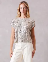 Blusa de manga corta cubierta de lentejuelas en tono champagne, con cuello redondo a la base y forro interno a tono.
