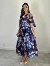 Vestido largo de estilo campesino confeccionado en organdí, con estampa floral chintz de estilo romántico. Presenta escote en V, cintura completamente elastizada y mangas tres cuartos con volados en los puños, además de una falda de diseño escalonado.
