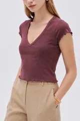 Remera manga corta de algodón con elastano, de diseño al cuerpo con escote en V y terminaciones con volados sutiles en mangas y ruedo.