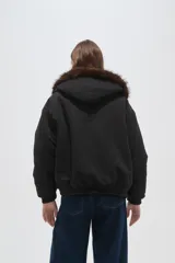 Campera bomber negra con cuello de piel sintética marrón, cierre frontal con cremallera y puños elásticos.